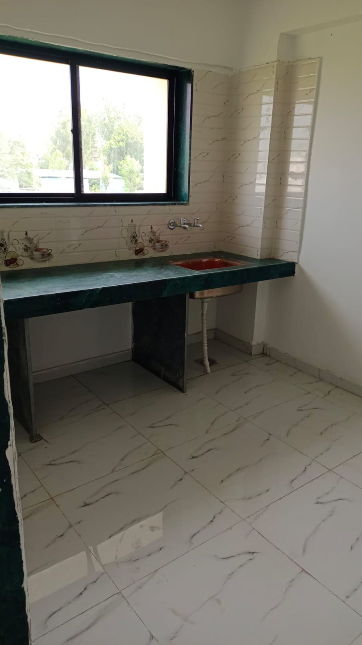 A flat kitchen at Habitat — granite counter, fitted sink, tiled backsplash