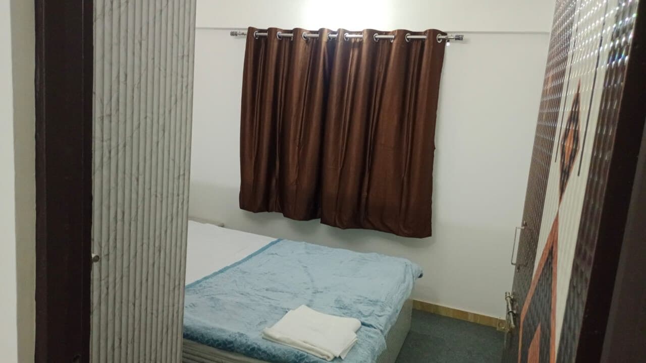A twin-share bedroom at Habitat — two beds, curtains, bright window